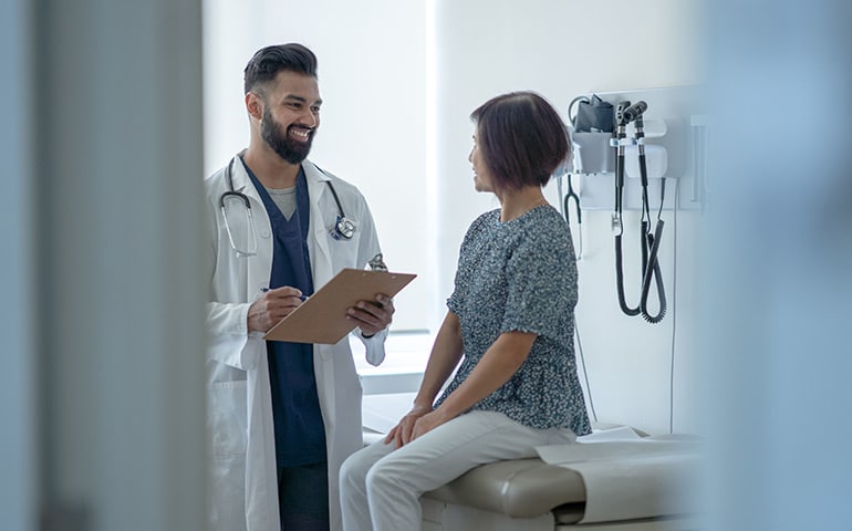 A physician and patient talking in an examination room